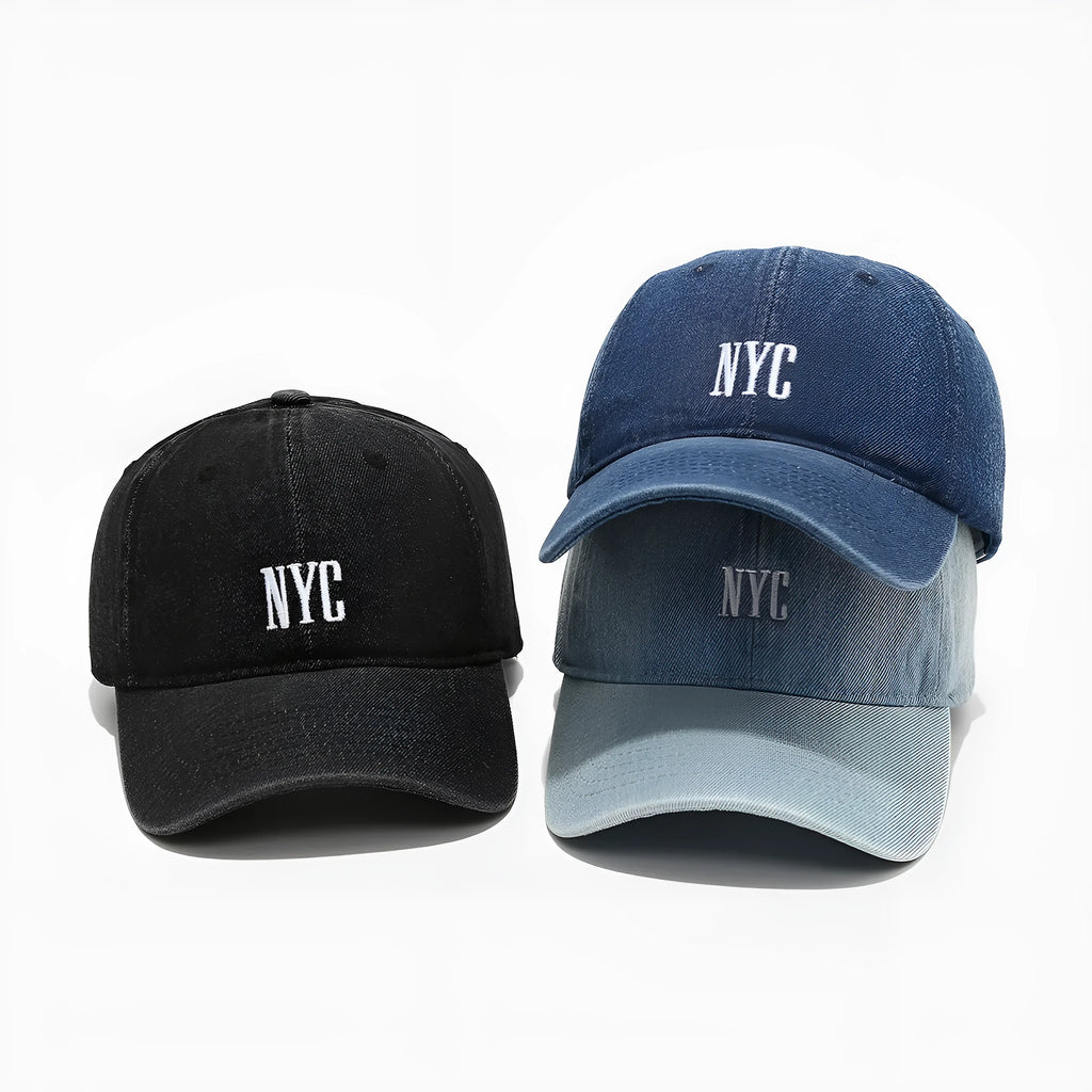 Light blue denim peaked cap with embroidered lettering on the front, showing adjustable strap.