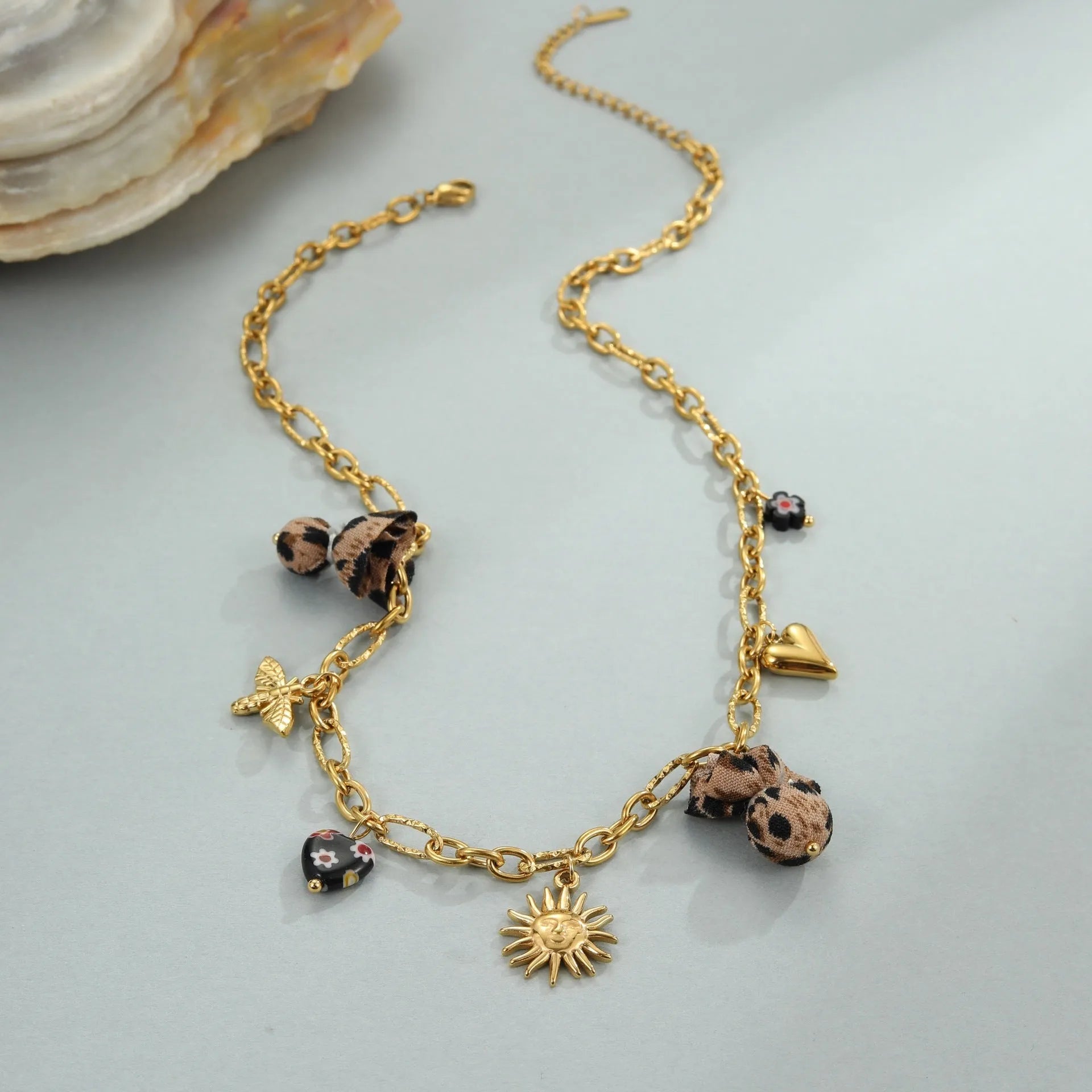 Gold plated stainless steel necklace with geometric leopard, heart, and flowers pendant on adjustable chain
