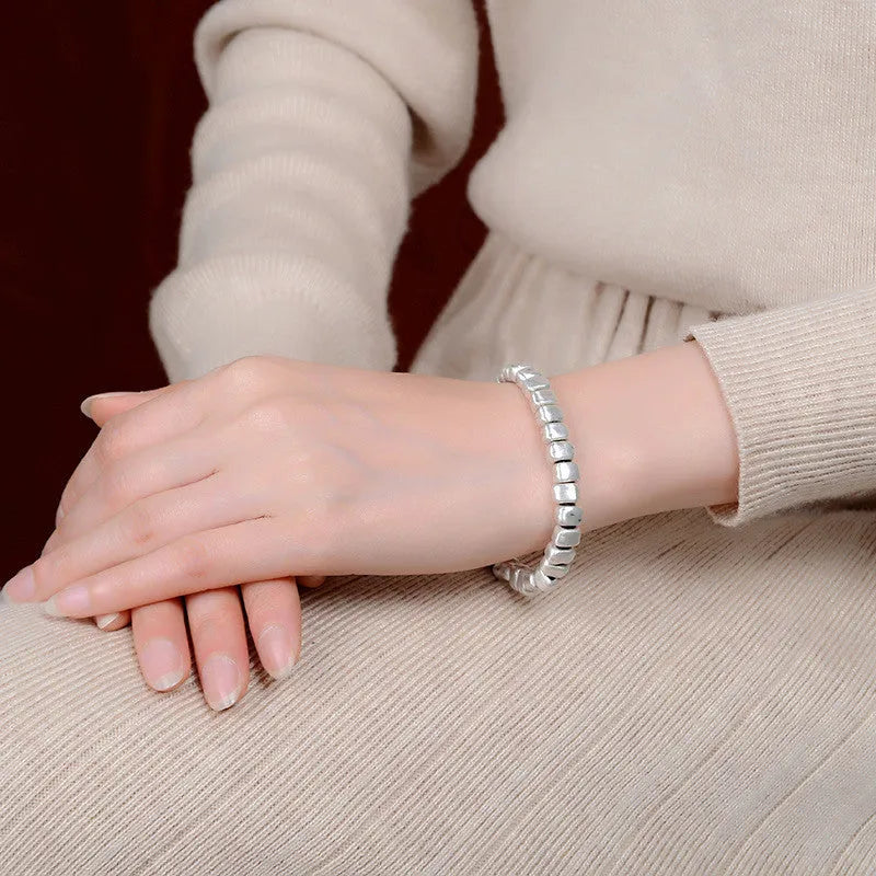 Handmade women's bracelet with irregular silver squares on wooden beads and elastic band