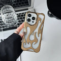Electroplated hollow flame pattern soft TPU phone case for Apple iPhone on a table.