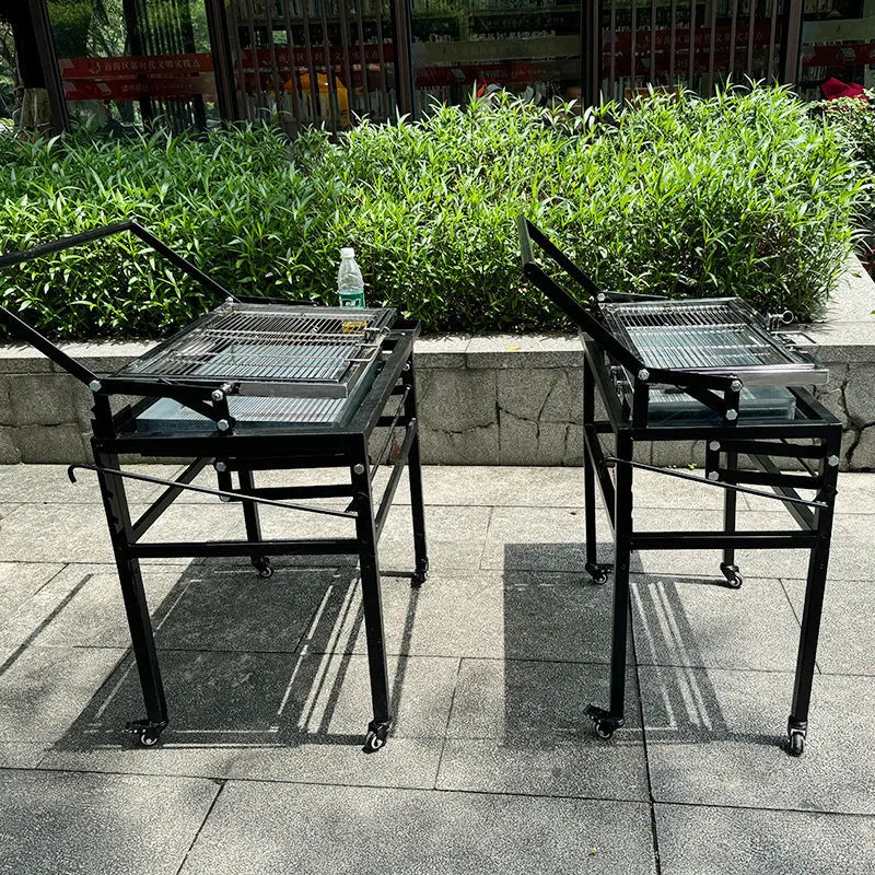 Large foldable charcoal barbecue oven set up in a garden for grilling.