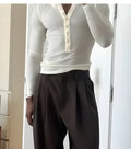 Men's cream coloured ribbed long-sleeve henley top with buttoned placket.