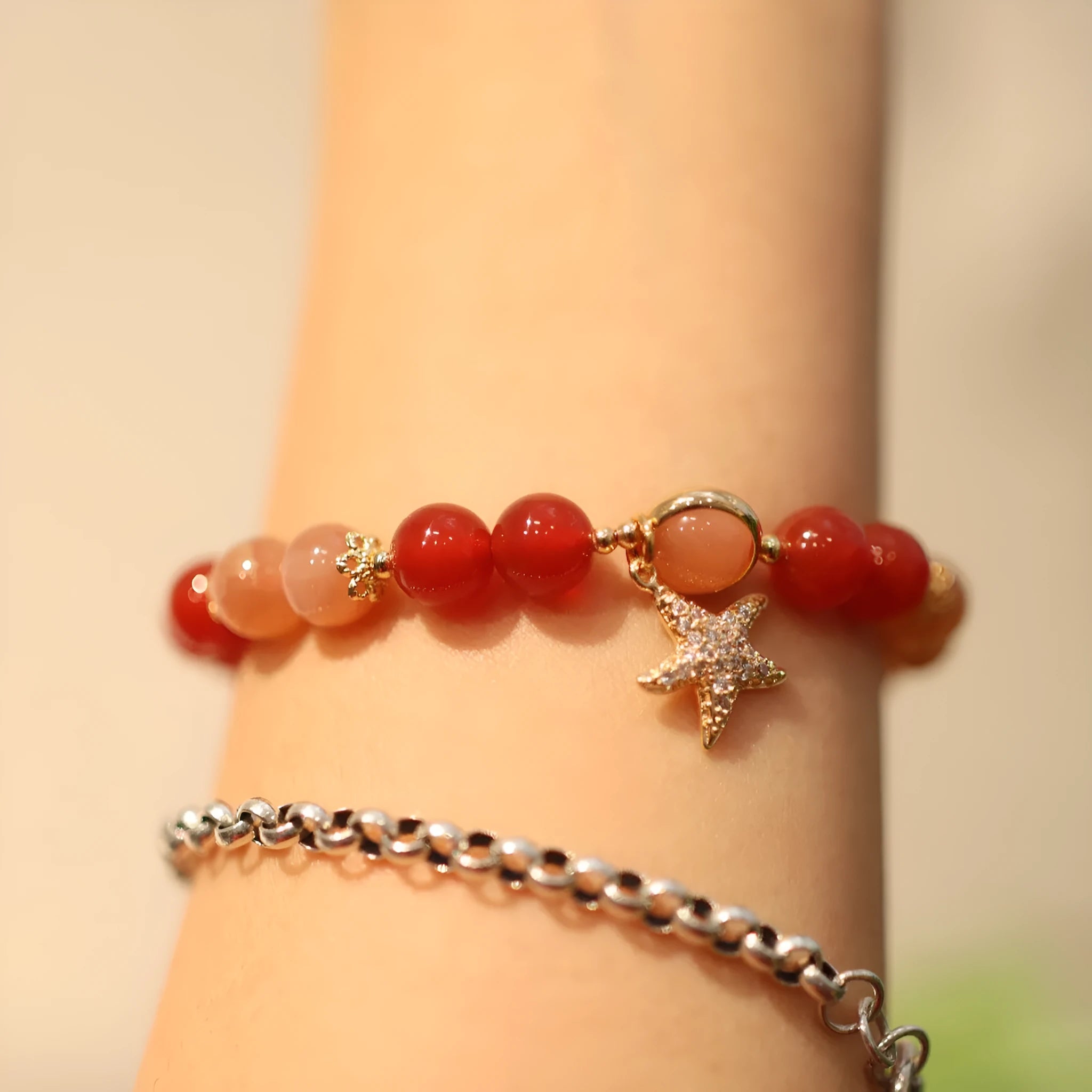 Handmade ethnic-style bracelet with sand orange Sunstone and 8mm red agate beads in a star pattern.