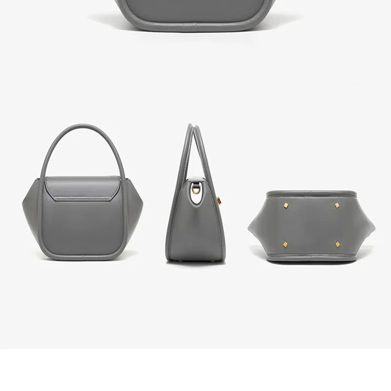 Women's wing-shaped leather tote bag with a latch buckle, shown in Atlantic blue with a cross-body strap.