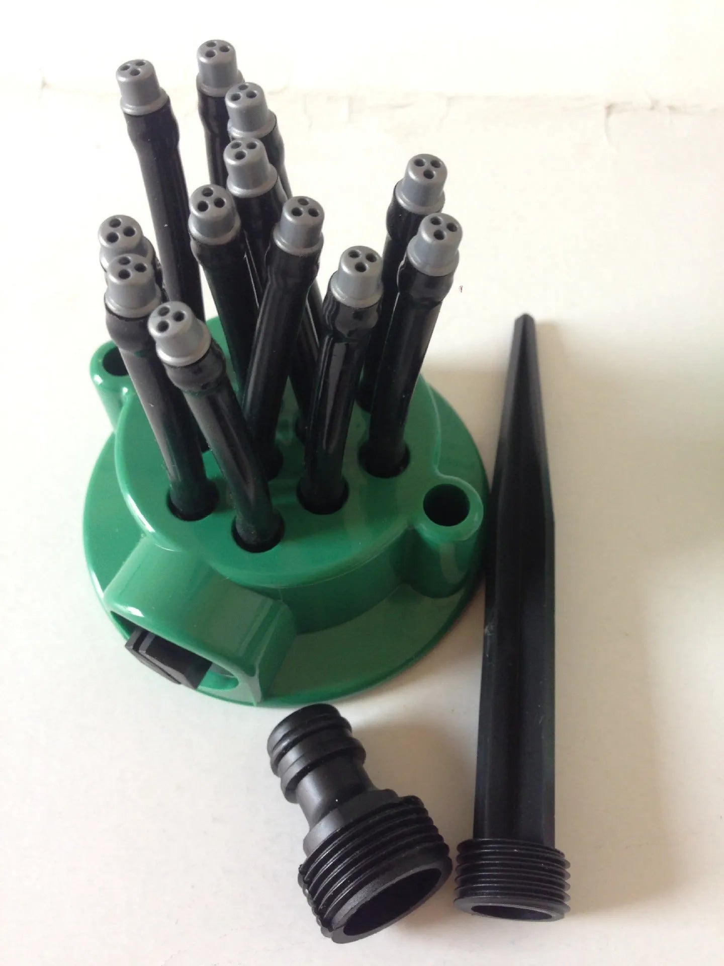 Green adjustable lawn sprinkler with flexible nozzles on a 9cm base