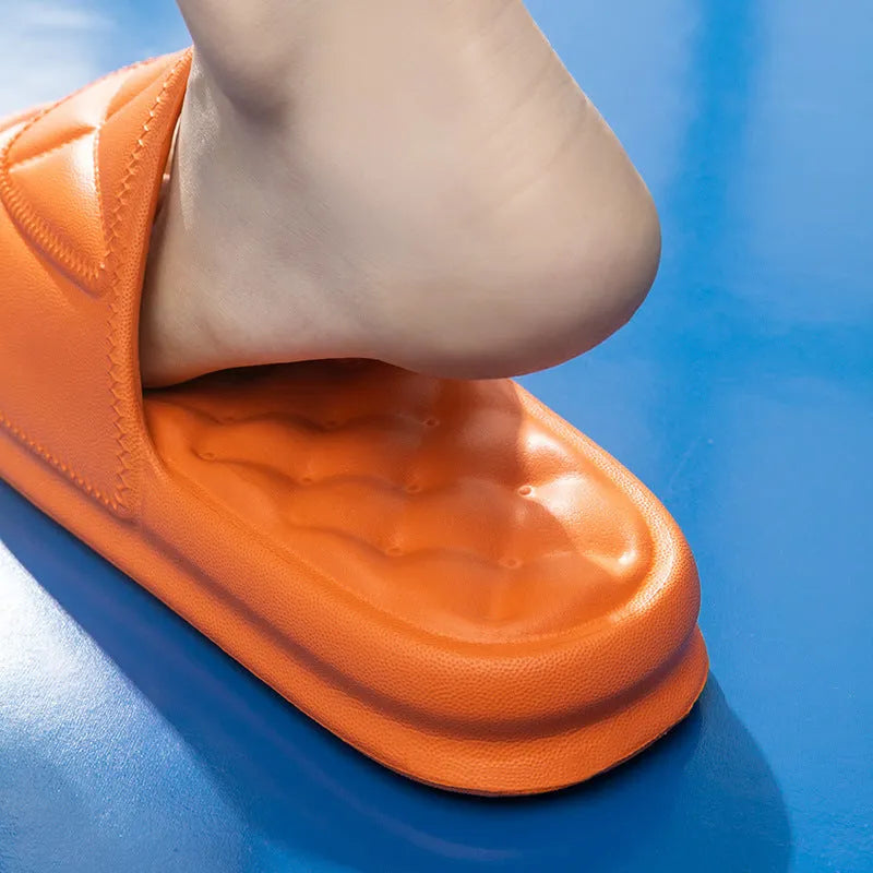 A pair of solid-colour EVA bathroom slippers with a thick, textured sole, shown on a bathroom floor.