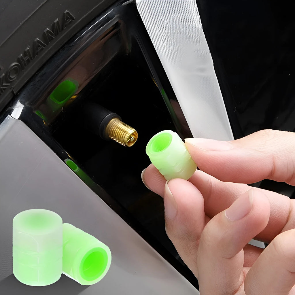 Black rubber luminous car tyre valve cap with glow-in-the-dark tip, shown next to a coin for scale.