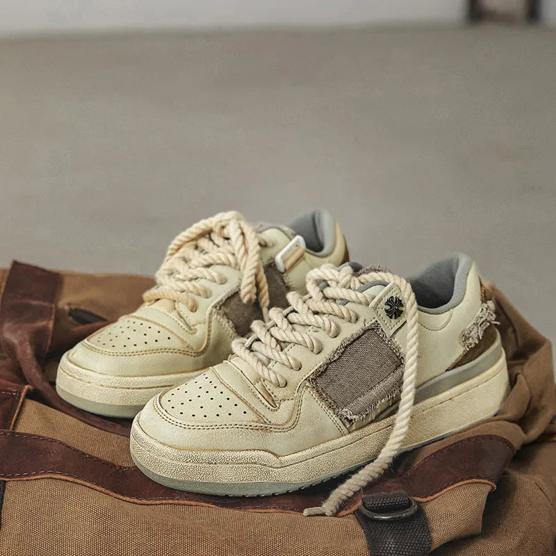 Beige low-top vintage skate shoes with round toe and front lace-up closure on a solid background.