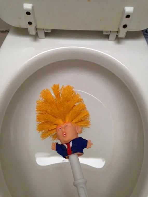 Yellow plastic Donald Trump novelty toilet brush with hanging slot.