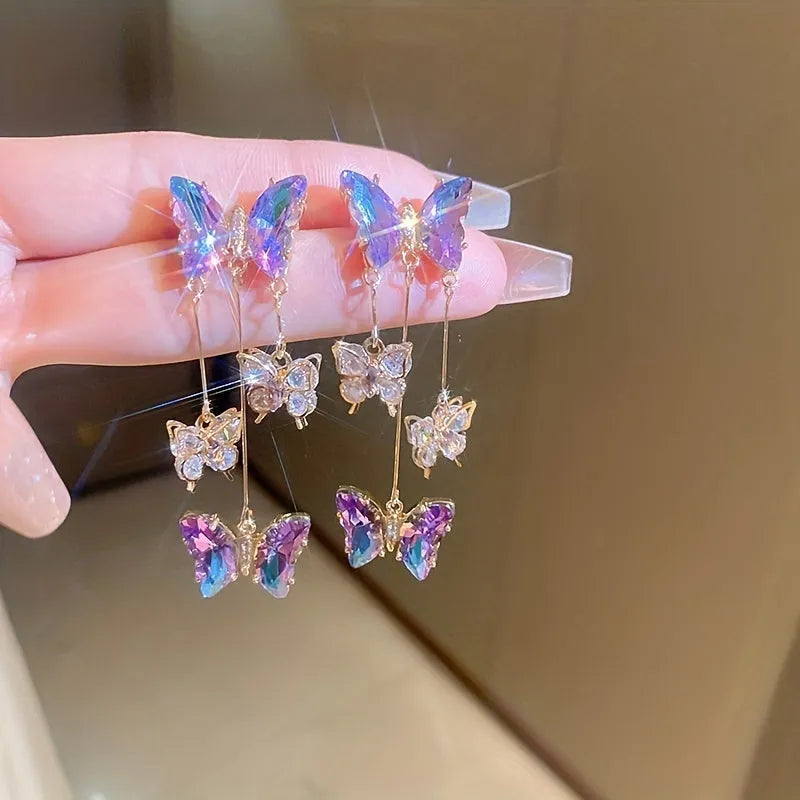 A pair of silver needle blue purple butterfly tassel earrings with crystal flowers on an alloy base.