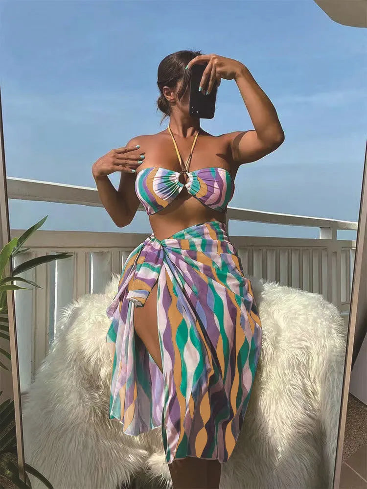 Women's three-piece bikini set with swimsuit top, briefs, and matching printed beach skirt in polyester fabric