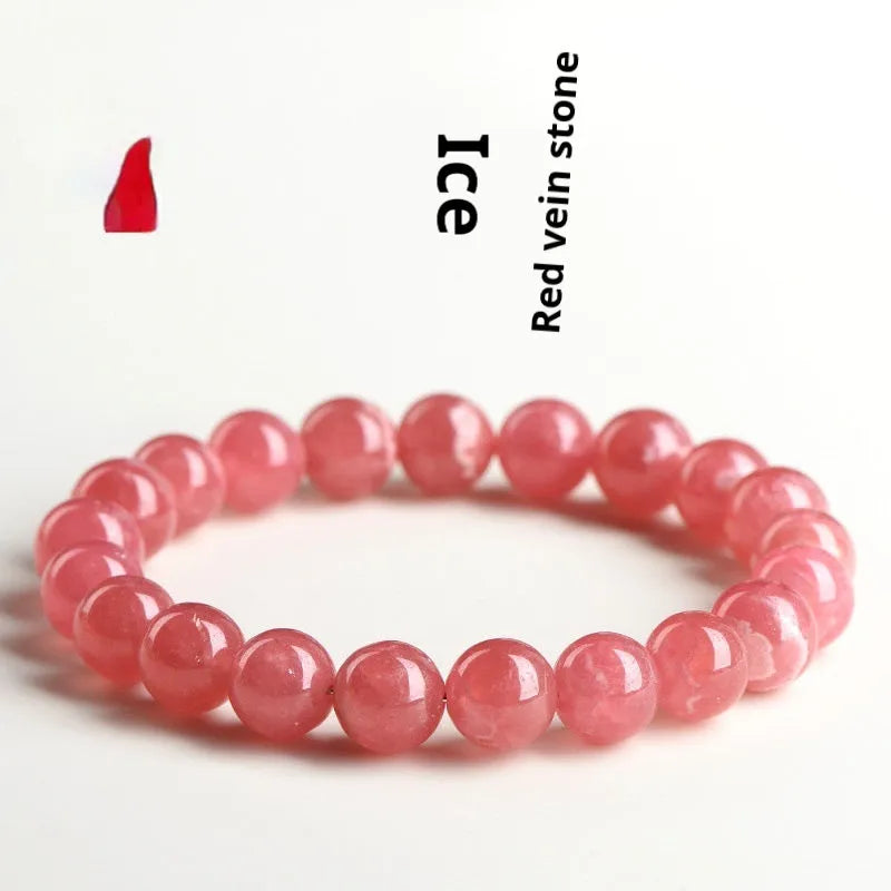 Women's geometric red rhodochrosite crystal bracelet with a longevity lock clasp on a wrist.