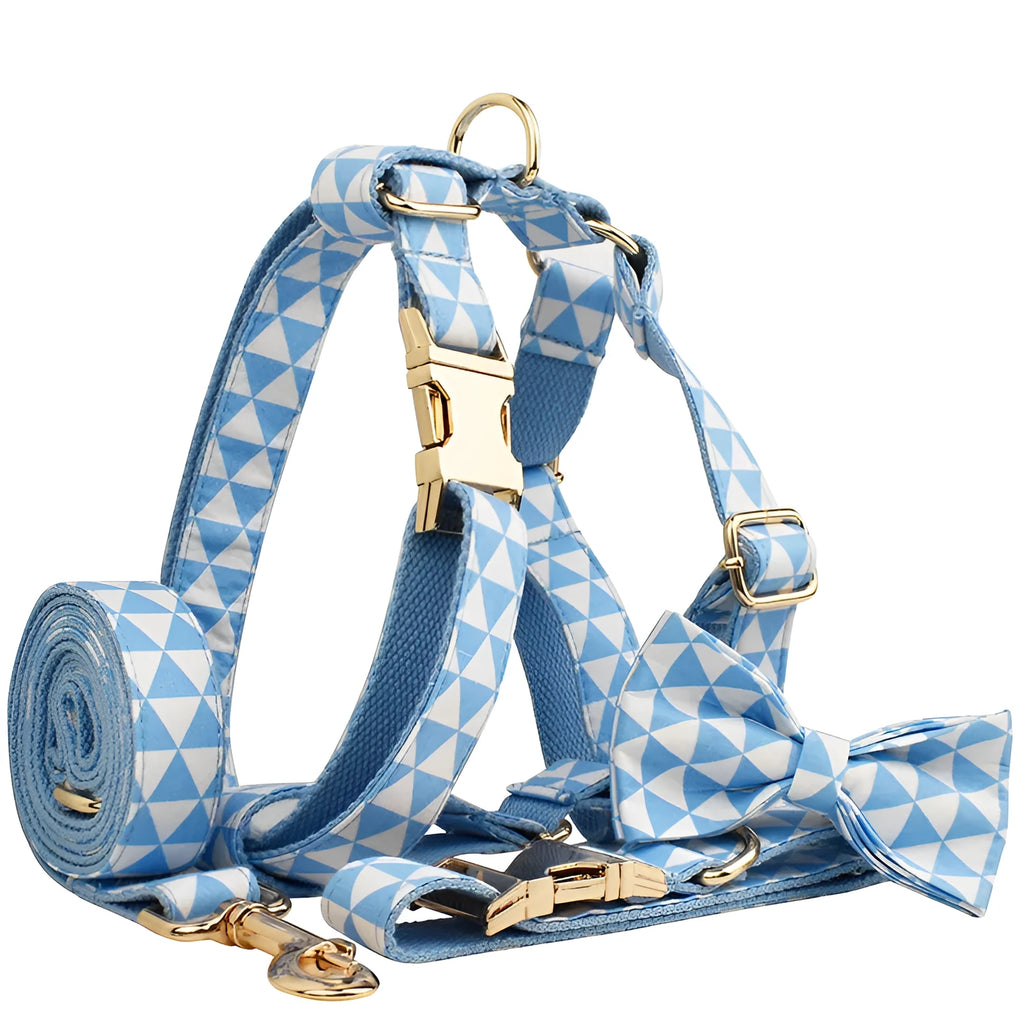 Blue cloth dog vest harness set with matching collar, leash, and decorative bow tie on a small dog