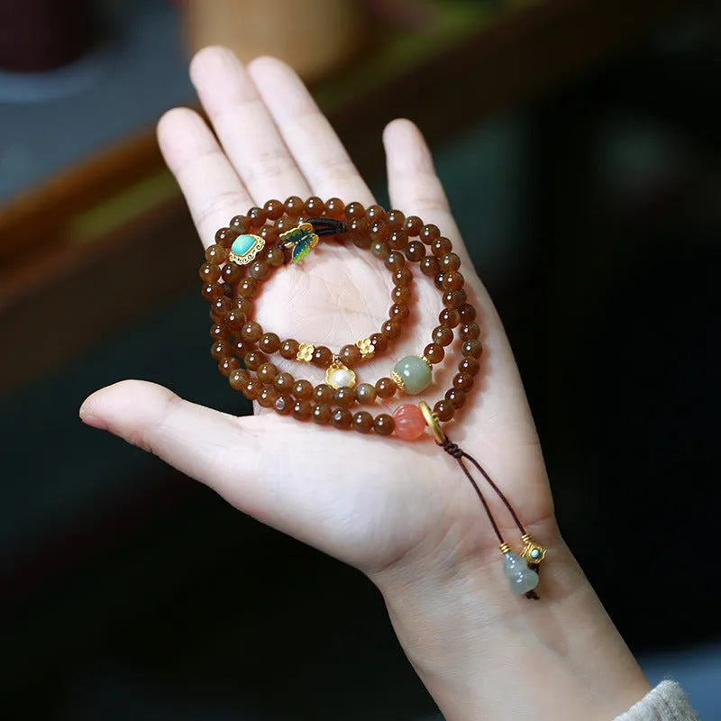 Brown Hetian jade bracelet with three-ring design featuring carved gourd and butterfly charms, silver-plated connectors