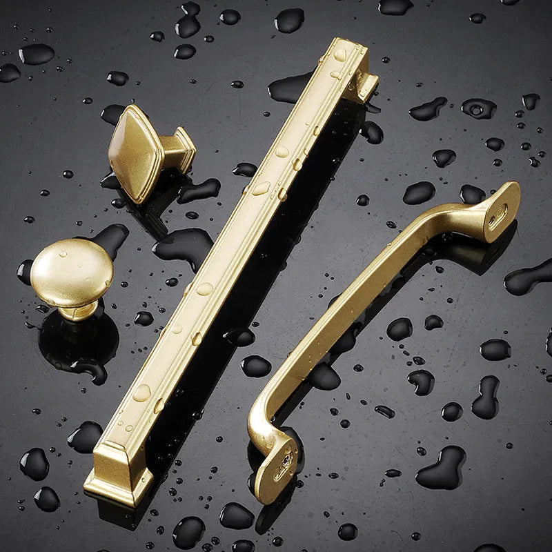 Gold T-shaped aluminium alloy cabinet door handle for single-hole mounting.