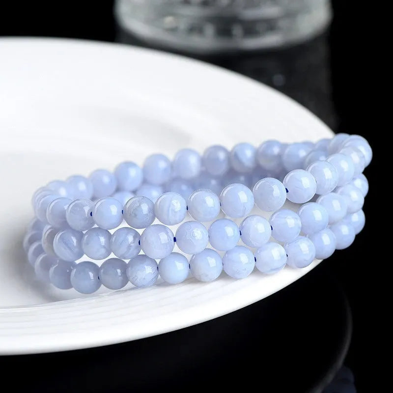 Natural blue agate bracelet showing scattered beads with blue striped pattern and three-circle design