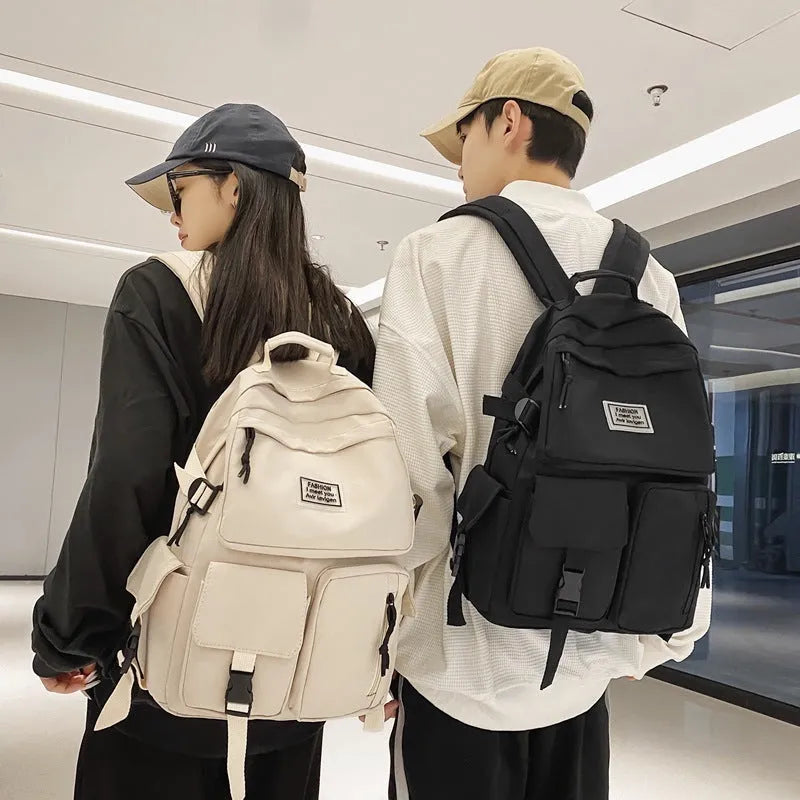 Black and white nylon student backpack with front pockets and laptop compartment.