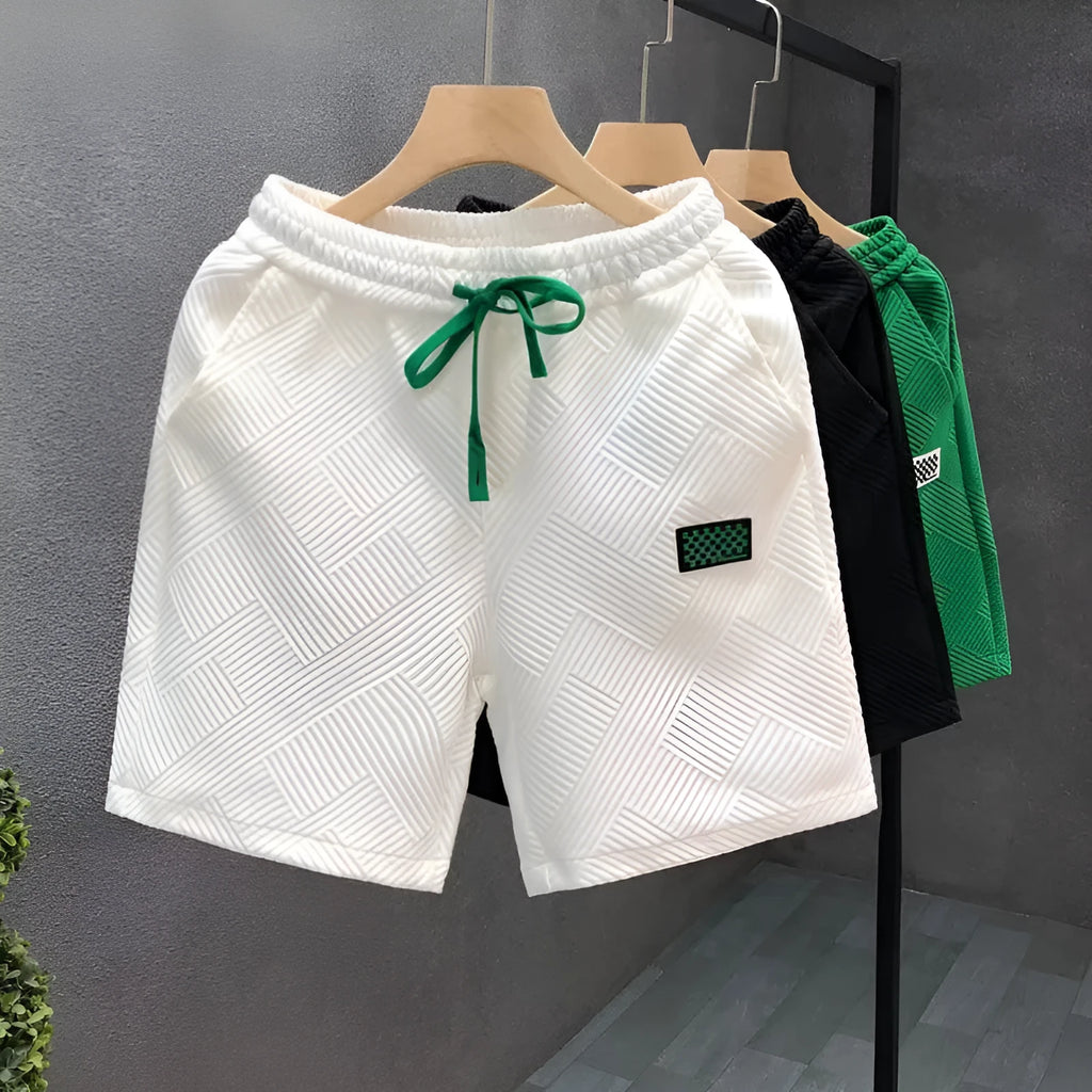 Men's solid colour polyester sports shorts on a hanger, showing elastic waistband.