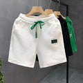 Men's solid colour polyester sports shorts on a hanger, showing elastic waistband.