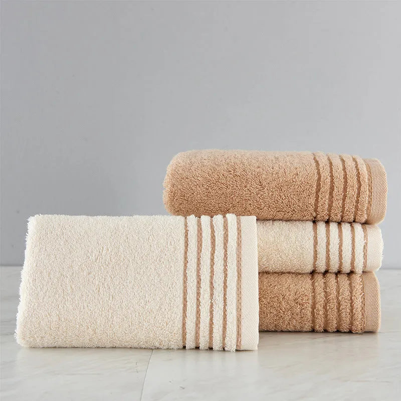 Beige and brown cotton bath towel set showing large bath towel, hand towel, and small face cloth.