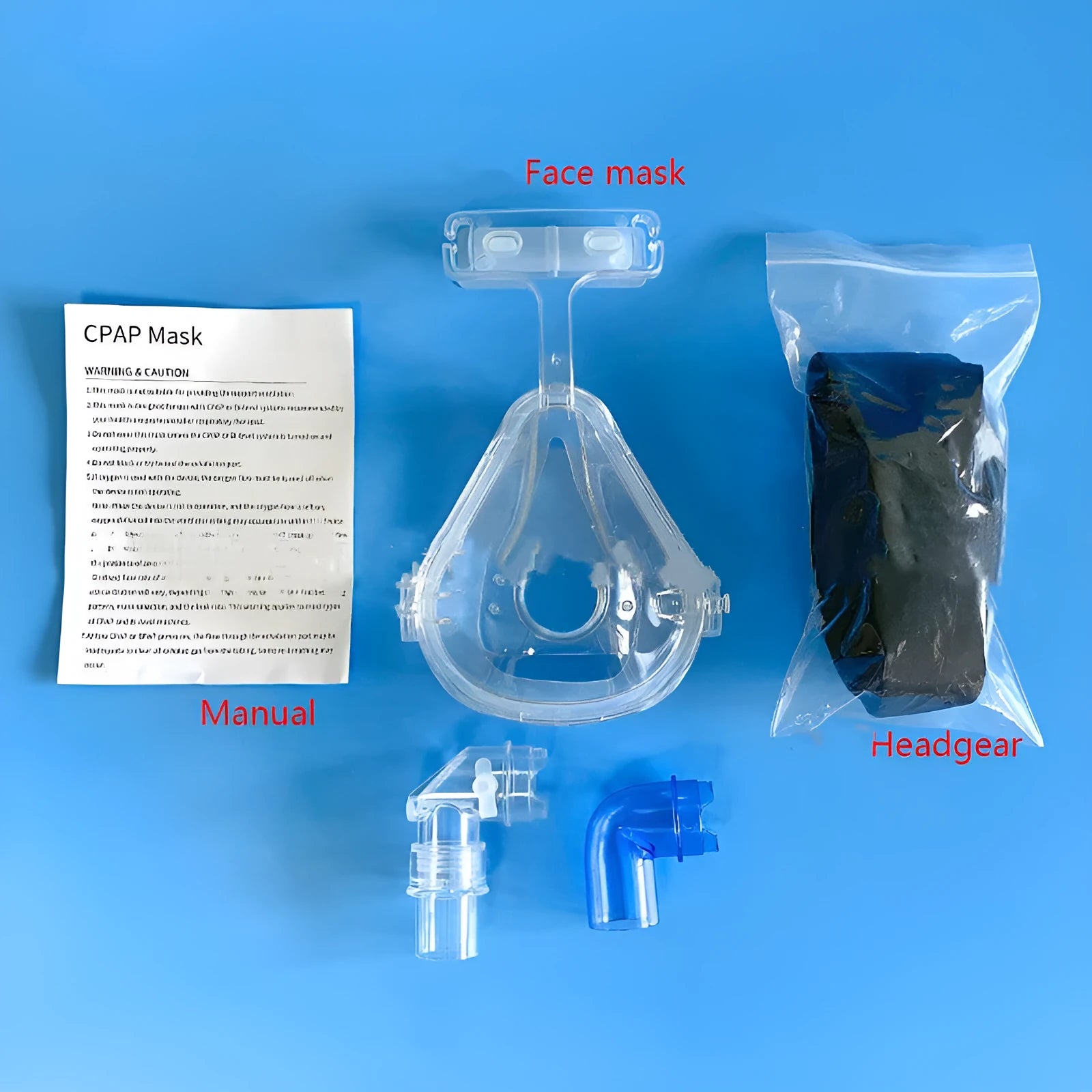 Transparent silicone CPAP breathing mask with headgear and two rotary adapter elbows on a white background.