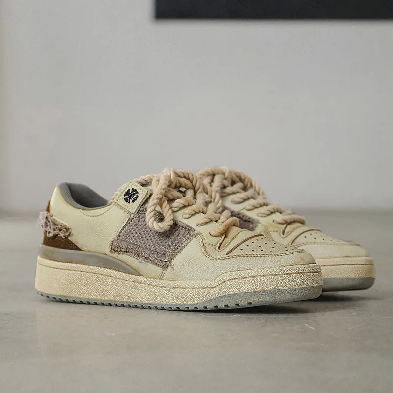 Beige low-top vintage skate shoes with round toe and front lace-up closure on a solid background.
