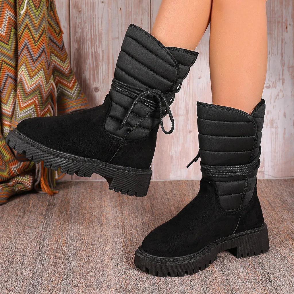 Women's chunky heel snow boots in suede with lace-up design and fleece lining, shown in black.