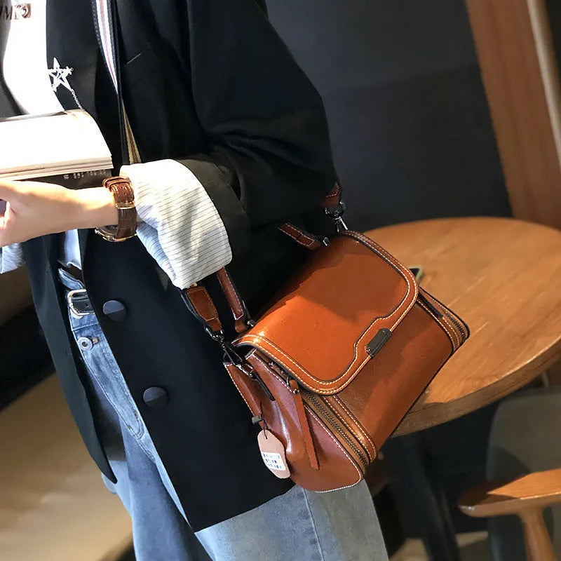 Women's brown genuine leather messenger bag with shoulder strap and internal pockets