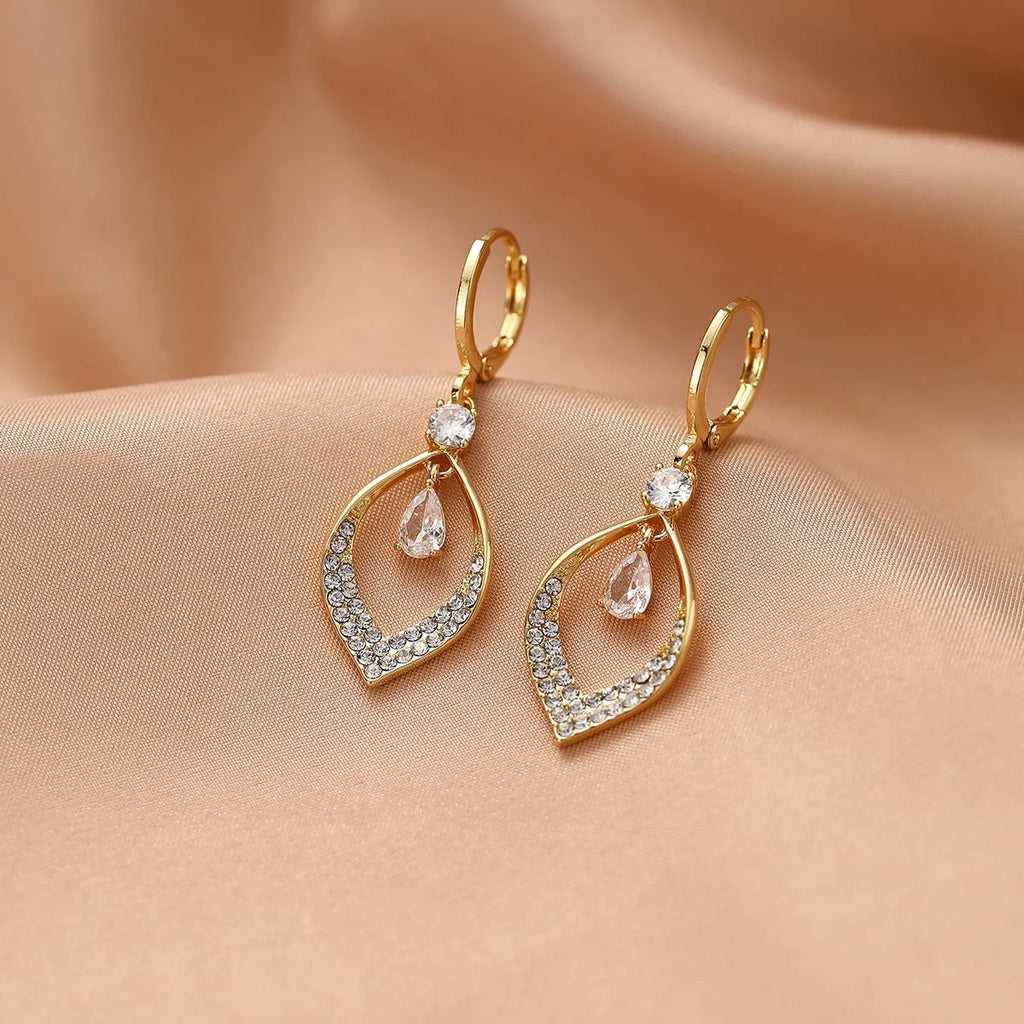Gold zircon teardrop tassel earrings with electroplated copper construction.