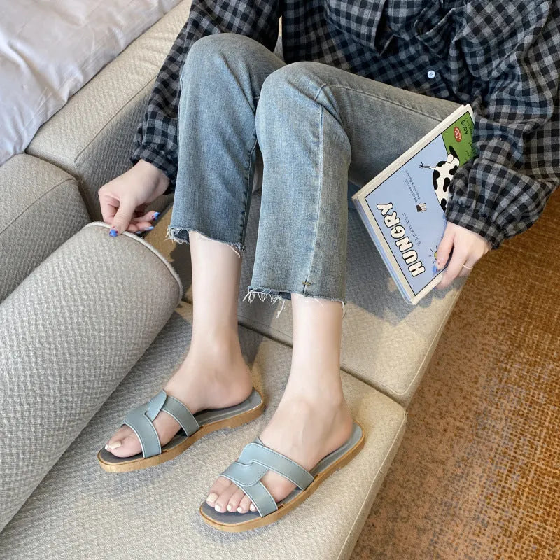Women's PVC flip flop slippers with a cross strap and toe ring in a solid colour.