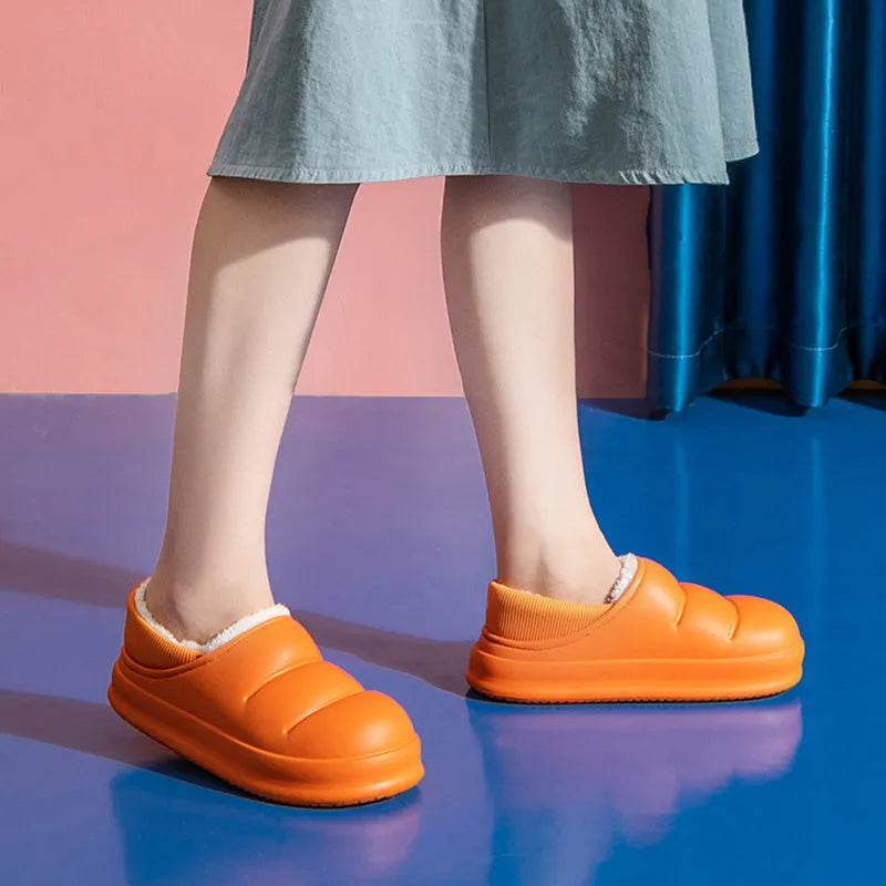 A pair of waterproof EVA couple slippers in green with a plush lining and non-slip sole.