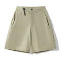 Men's quick-drying sports shorts in khaki colour with 3D cut and elastic waistband on a plain background.
