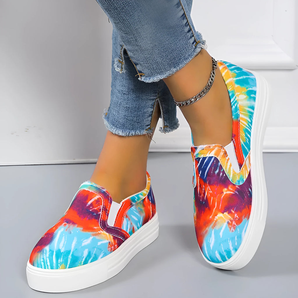 Women's low-top canvas trainers in blue, green, black and colourful patterns with a flat rubber sole.
