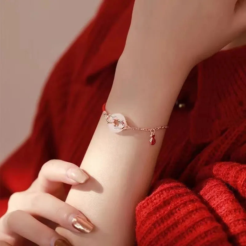 Festive koi bracelet with fishtail design and peace buckle closure on red rope