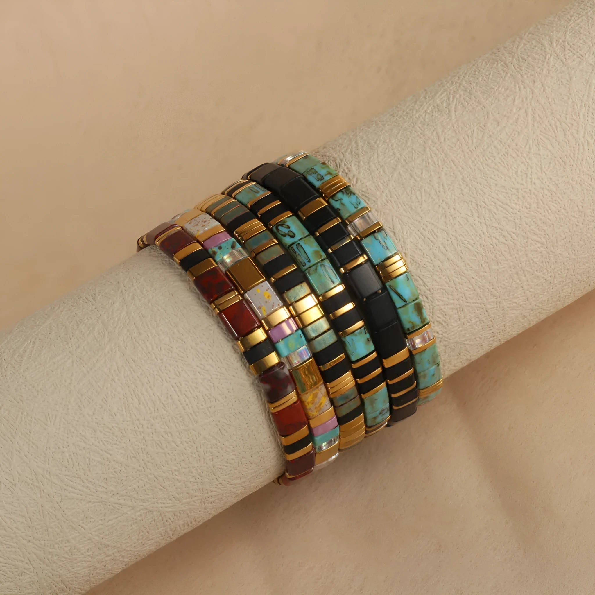 Geometric beaded bracelet with round elements in milky white, black, green, blue, or red.