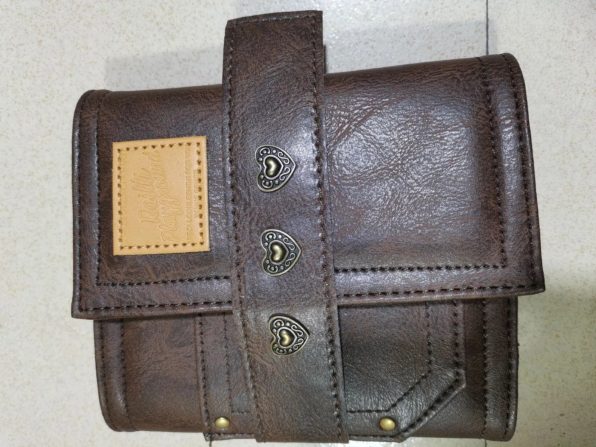 Brown retro-style notebook with a buckle closure and loose-leaf binder binding