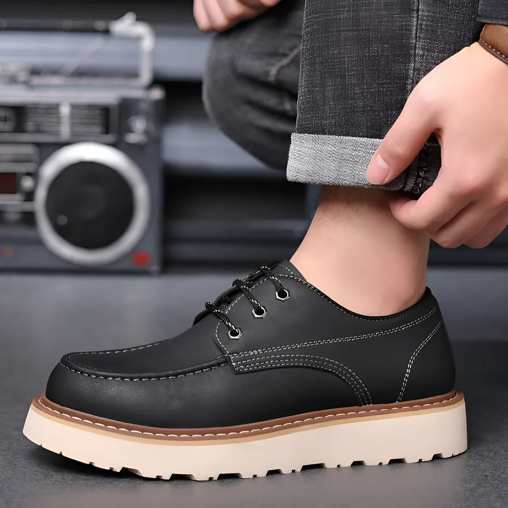 Men's low-top black Martin boots with round toe and rubber sole on a neutral background.