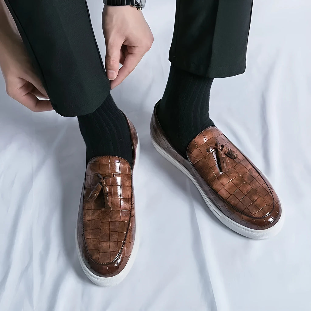 Men's black business casual sneakers with tassel detail on artificial PU upper and rubber sole.