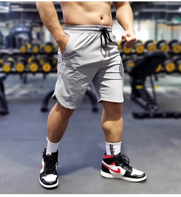 Men's black quick-drying nylon sports running shorts on a grey background.