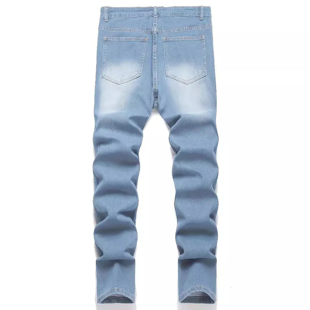 Men's denim jeans with worn-out patch detail in light blue, mid-waist tight fit British style