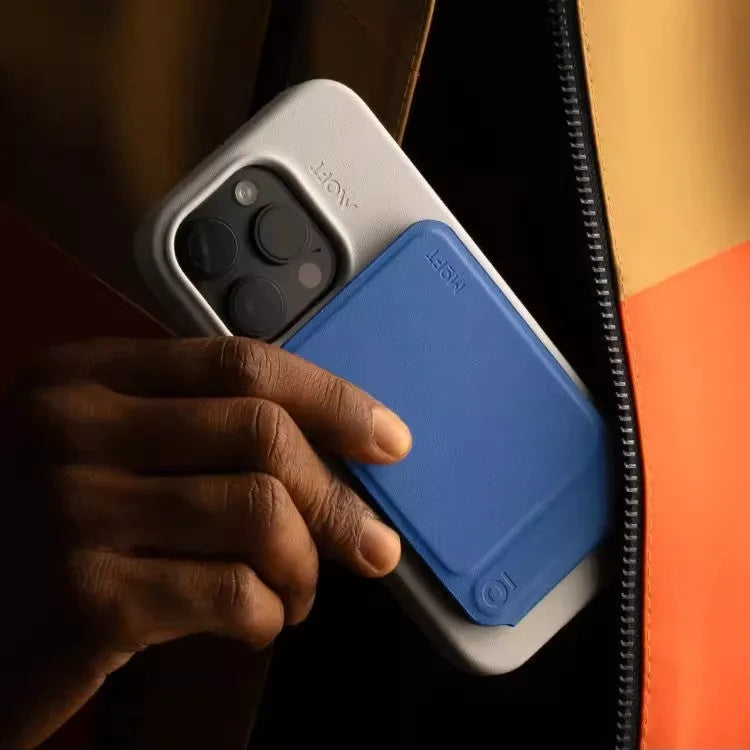 Black magnetic mobile phone holder case on a car dashboard, showing compact size and magnetic plate.