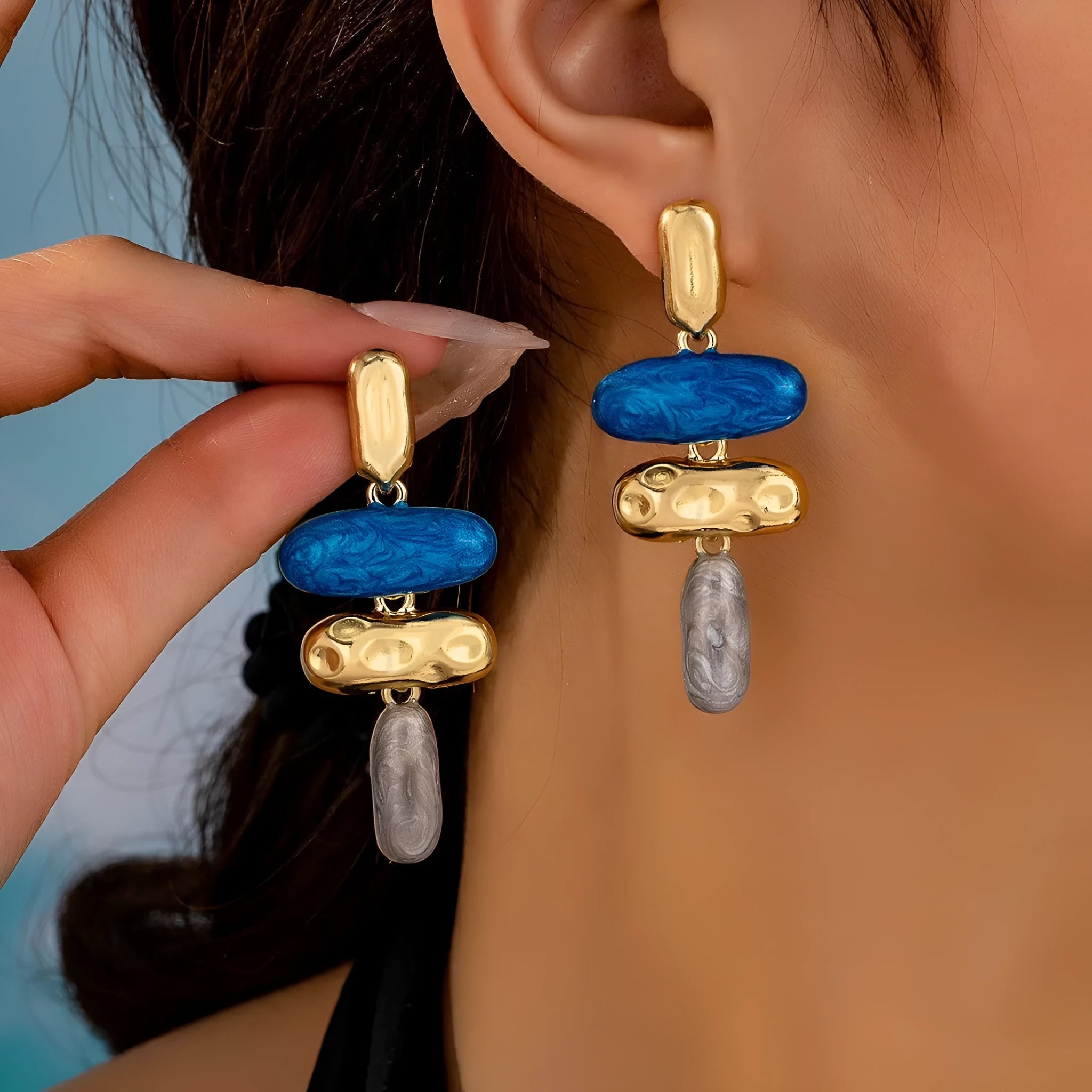 A pair of geometric-shaped stud earrings with a multicolour electroplated metal finish.