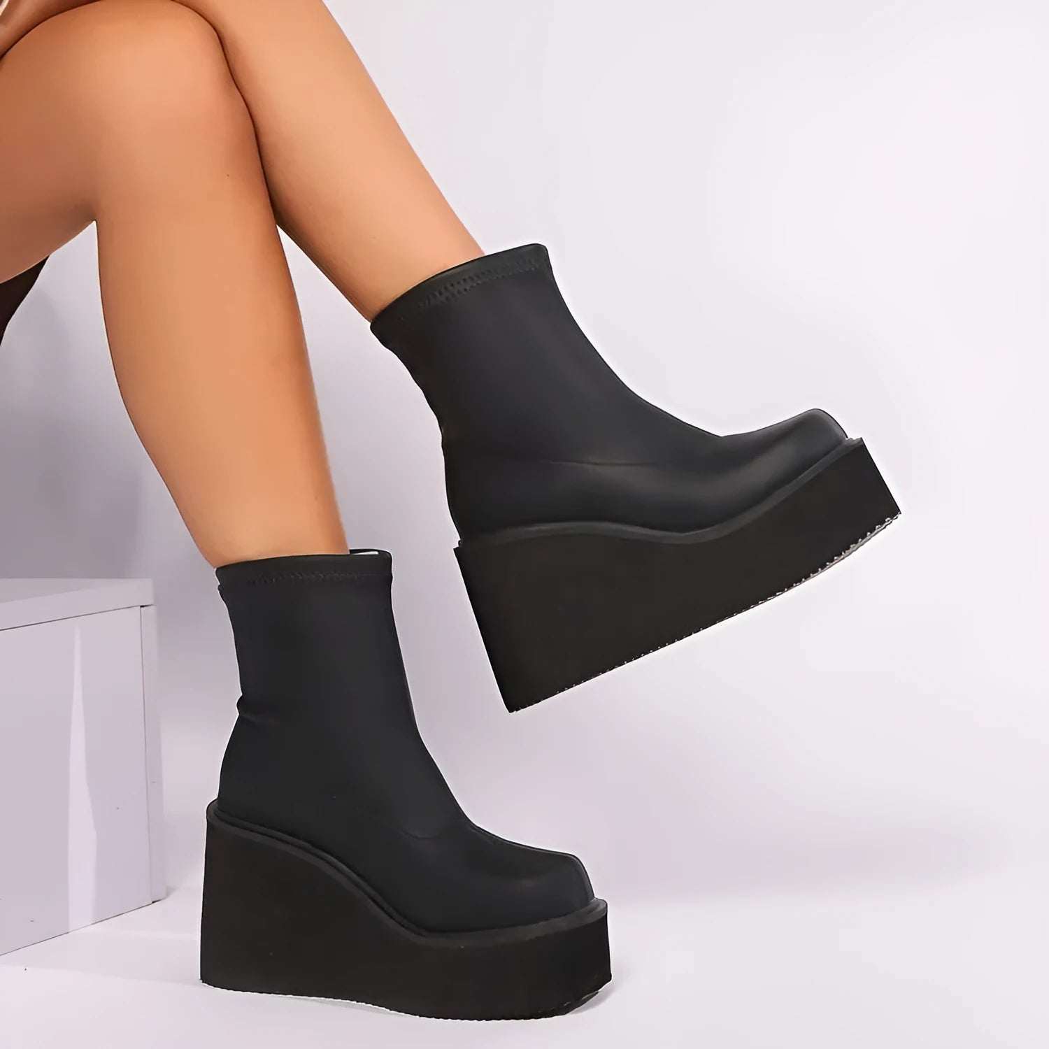 Black plus size women's ankle boots with a wedge heel and round toe.