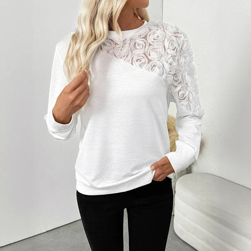 White women's long sleeve floral print top with loose fit on a hanger.