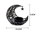 Gold crescent moon metal candle holder with hollow pattern on a wooden table
