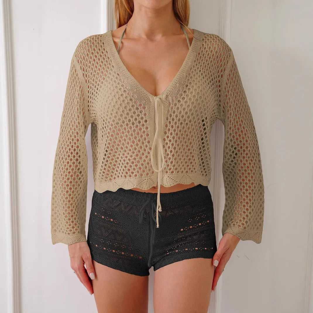 Short apricot hollow woven women's cardigan blouse with bell sleeves on a hanger