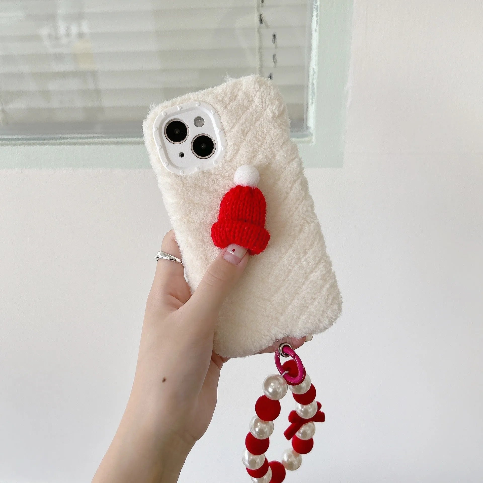Red silicone iPhone back cover with attached plush Christmas hat bracelet