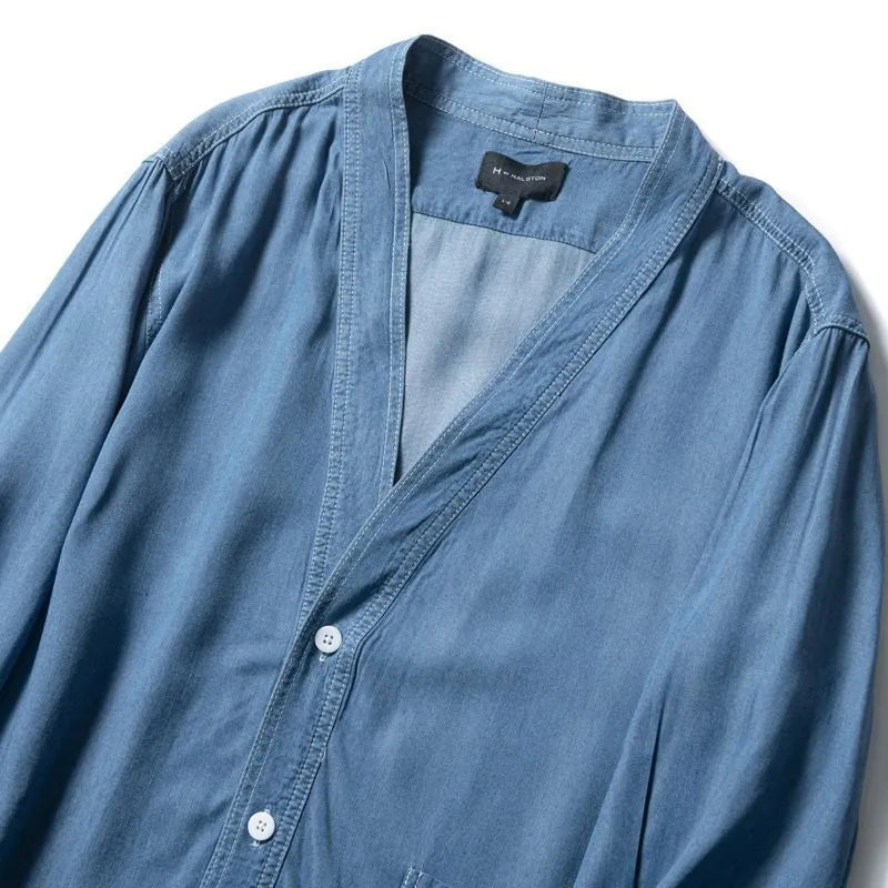 Men's dark blue denim coat with three-quarter sleeves and V-neck collar showing front pocket detail