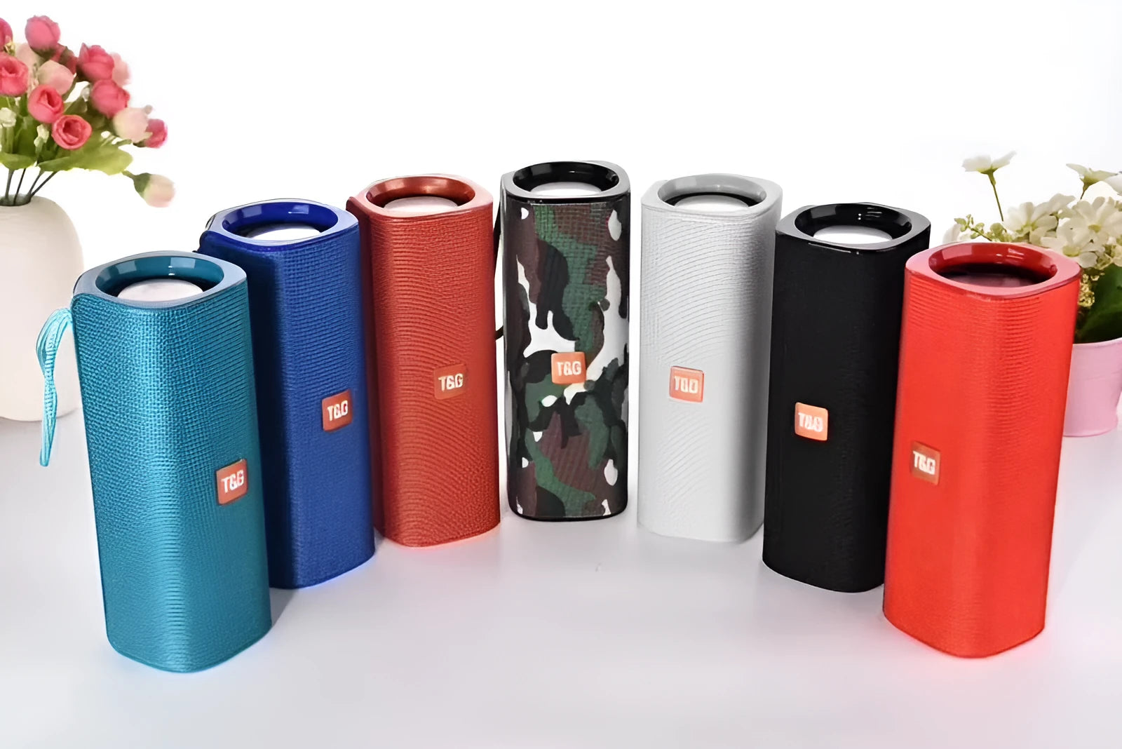 Wireless Bluetooth speaker with cloth cover in multiple colours showing front speaker grille and control buttons