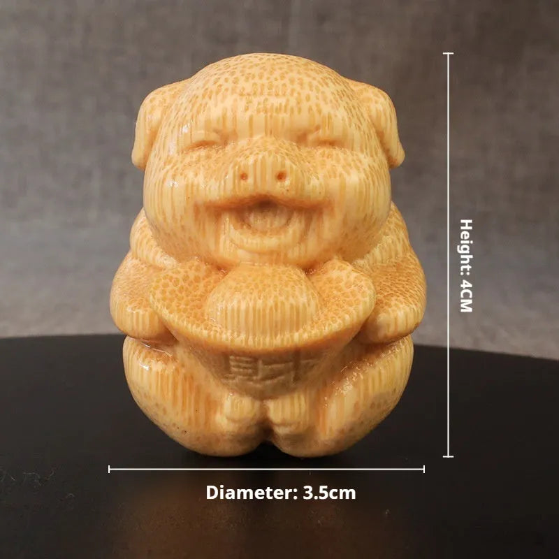 Small cute Fulu Pig bamboo carving ornament on a surface, showing its ingot shape.